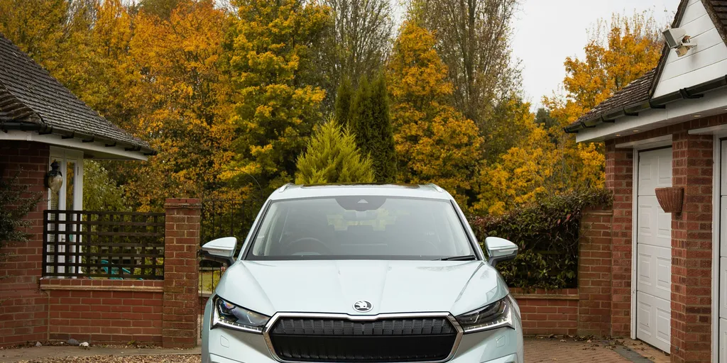 Škoda Enyaq iV in Mintgrün von vorn in einer Einfahrt